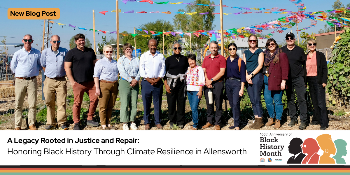 A dozen people smiling for a photo with flag banners and trees behind them. Celebrating 100 years of Black History Month Logo.